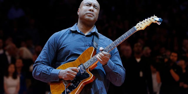 In this Feb. 1, 2014, file photo, former New York Yankee baseball player Bernie Williams plays the nation anthem on a guitar before an NBA basketball game between the Miami Heat and the New York Knicks, in New York.