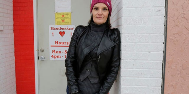 Dec. 16, 2014: Windie Lazenko, with the anti-trafficking group 4her North Dakota, stands for a photo in front of a club in Williston, N.D. As a 13-year-old runaway, Lazenko says she was bought and sold for sex. Prostitution, pornography and strip clubs followed. Then she walked away from it all.