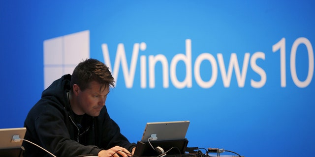 File photo - A man works on a laptop computer near a Windows 10 display at Microsoft Build in San Francisco, California April 29, 2015.