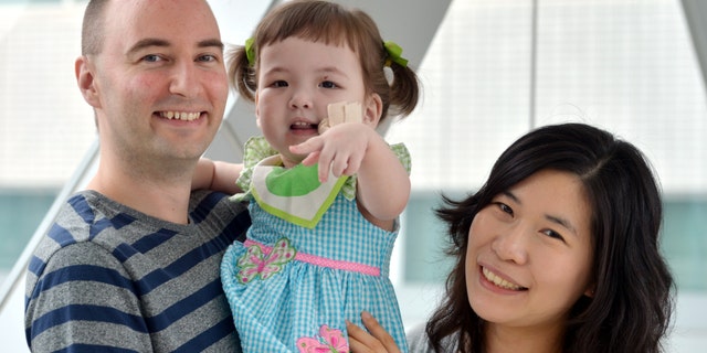 Hannah Warren, 2, poses with her parents Lee Young-mi and Darryl Warren at Seoul National University Hospital in Seoul, South Korea. Hannah received a new windpipe made from her own stem cells in a landmark operation on April 9, 2013, at Children's Hospital of Illinois in Peoria, Ill.