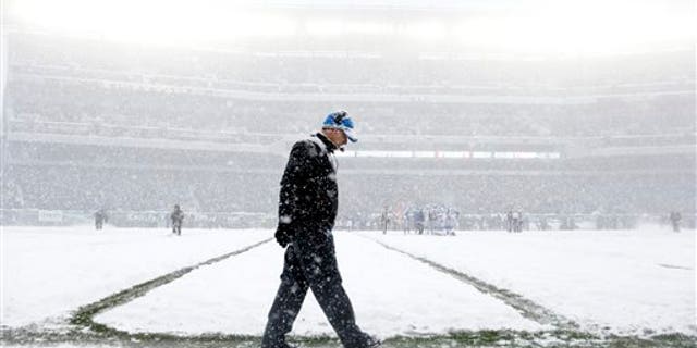 Detroit Lions head coach Jim Schwartz walks the sidelines as snow falls during the first half of an NFL football game against the Philadelphia Eagles, Sunday, Dec. 8, 2013, in Philadelphia. (AP Photo/Matt Rourke)