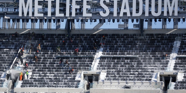 Jan. 22, 2014: Workers shovel snow off the seats at MetLife Stadium as crews removed snow ahead of Super Bowl XLVIII following a snow storm.