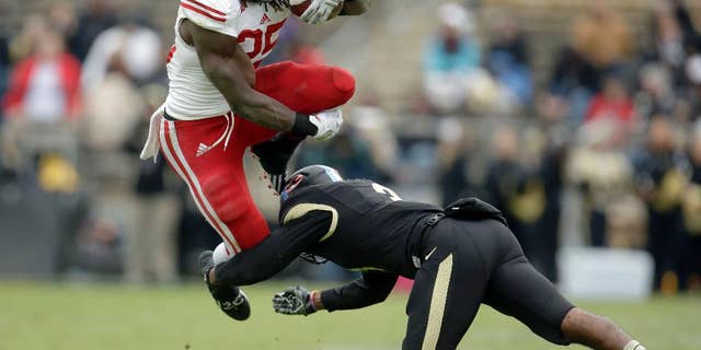Wisconsin running back Melvin Gordon, left, leaps to avoid a tackle by Purdue defensive back Leroy Clark during the second half of an NCAA college football game in West Lafayette, Ind., Saturday, Nov. 8, 2014. Wisconsin won 34-16. (AP Photo/AJ Mast)