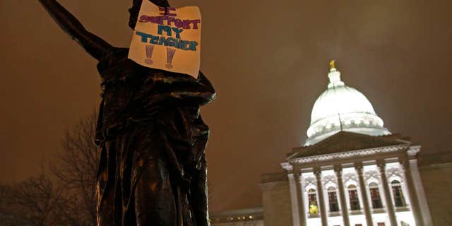 February 21: A sign that says "I support my teacher" hangs on a statue outside the state Capitol in Madison, Wis. Twice as many public school teachers decided to retire this year as in each of the past two years.