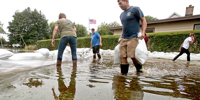 Residents layered sandbags to protect property from flooding.