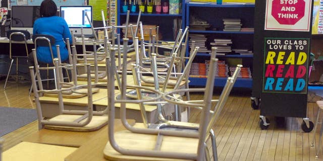 DeLois Bates works in her empty third grade classroom at Janes Elementary School in Racine, Wis., on Thursday Feb. 17, 2011. School districts around Wisconsin canceled classes Thursday as state lawmakers were prepared to pass a momentous bill that would strip government workers of nearly all collective bargaining rights. (AP Photo/Journal Times, Mark Hertzberg)