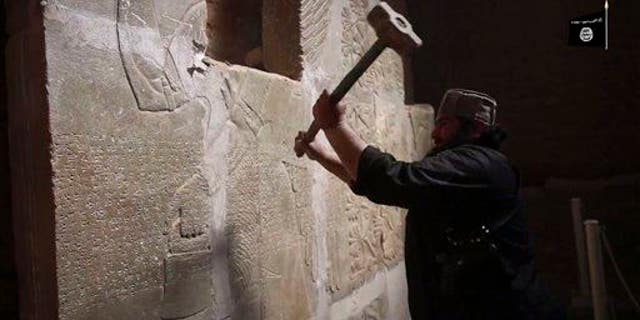 This image made from an apparent ISIS video posted April 11, 2015, purports to show a militant taking a sledgehammer to an Assyrian relief at the site of the ancient Assyrian city of Nimrud in Iraq.