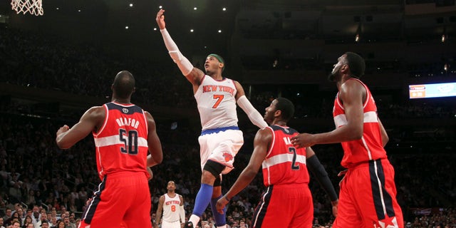 New York Knicks' Carmelo Anthony (7) goes up past Washington Wizards' Emeka Okafor (50) John Wall and Chris Singleton during the second half of n NBA basketball game, Tuesday, April 9, 2013, at Madison Square Garden in New York. The Knicks won 120-99. (AP Photo/Mary Altaffer)