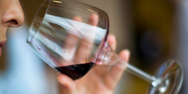 A woman smells a glass of red wine from Spain during a tasting session at Vinexpo Asia-Pacific, the International Wine and Spirits Exhibition for the Asia-Pacific region, in Hong Kong May 28, 2008. REUTERS/Victor Fraile (CHINA) - RTX68PE