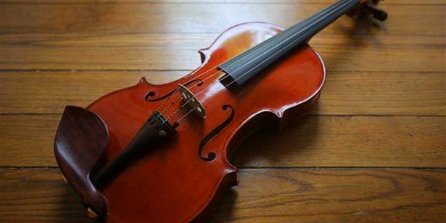 In this June 4, 2014, file photo, a finished violin made by Rose Clancy lies in her studio in Chatham, Mass.