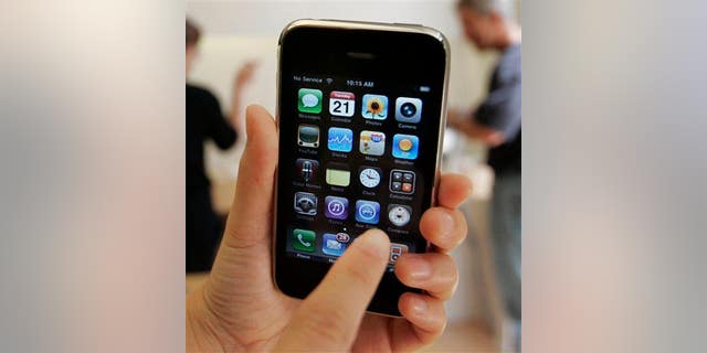 In this July 21, 2009, file photo, a customer displays an Apple iPhone 3GS at an Apple store in Palo Alto, Calif.