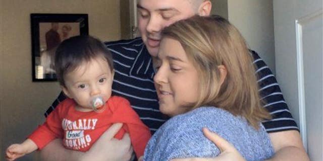 In this Tuesday, March 24, 2015 photo, Josh Dall-Leighton, holding son Christopher, hugs Christine Royles as they meet for the first time, at his home in Windham, Maine.