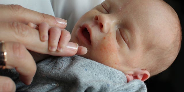 Oct. 6, 2014: Vincent, the first baby born to a woman who had a womb transplant, is cradled by his mother at an undisclosed location in Sweden.