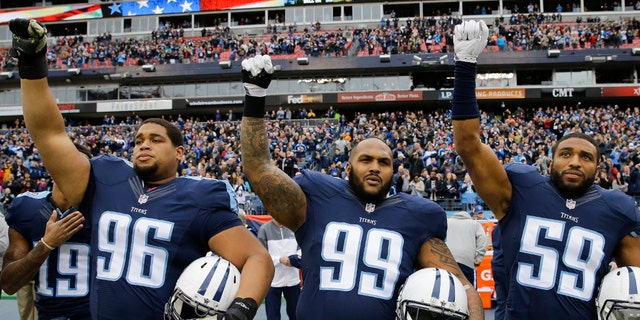 Tennessee Titans players Al Woods (96), Jurrell Casey (99), and Wesley Woodyard (59) raise their fists at the end of the national anthem before an NFL football game against the Houston Texans on Jan. 1, 2017, in Nashville, Tenn.