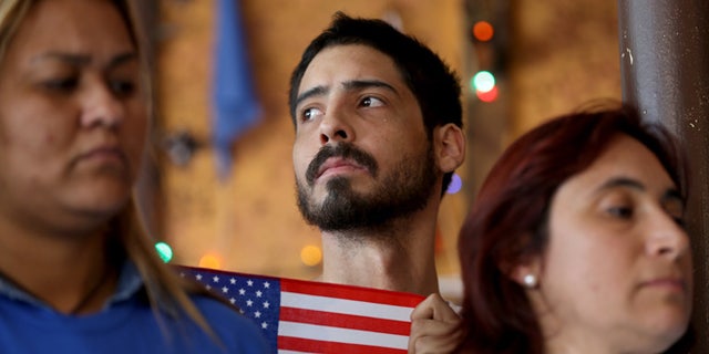 Dian Alarcon, originally from Colombia, stands with others during a press conference to protest the district court judge in Brownsville, Texas, who issued a preliminary injunction that temporarily blocks the implementation process of President Barack Obama's Executive Action on immigration on February 17, 2015 in Miami, Florida. (Photo by Joe Raedle/Getty Images)