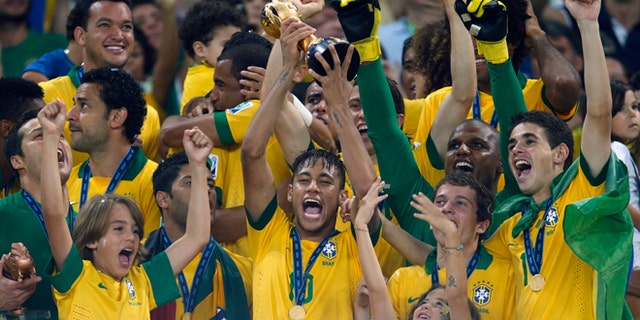 FILE - This Sunday, June 30, 2013 file photo shows Brazil's Neymar, center, as he lifts the trophy after winning the soccer Confederations Cup final between Brazil and Spain at the Maracana stadium in Rio de Janeiro, Brazil. (AP Photo/Victor Caivano, File)