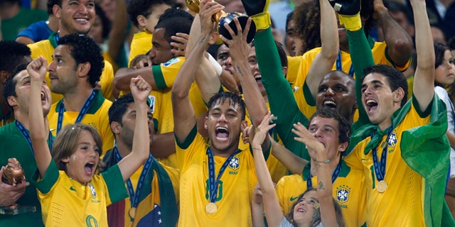 FILE - This Sunday, June 30, 2013 file photo shows Brazil's Neymar, center, as he lifts the trophy after winning the soccer Confederations Cup final between Brazil and Spain at the Maracana stadium in Rio de Janeiro, Brazil. (AP Photo/Victor Caivano, File)