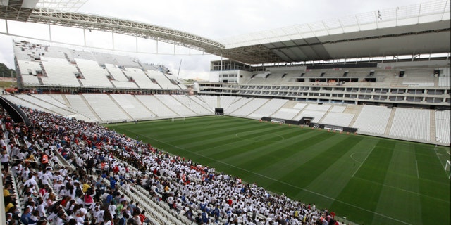People stand in the bleachers during an infrastructure test at Arena de Sao Paulo Stadium, one of the venues for the 2014 World Cup.