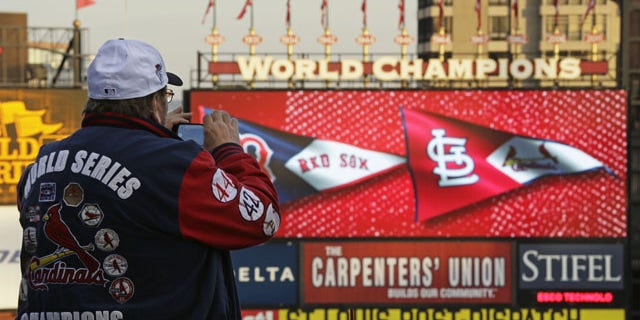 October 28, 2013: John Koenig takes a photo as players warm up for Game 5 of baseball's World Series between the Boston Red Sox and the St. Louis Cardinals in St. Louis. (AP Photo/Charlie Riedel)