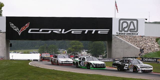 ELKHART LAKE, WI - JUNE 21: (L-R) Alex Tagliani, driver of the #22 Discount Tire Ford, Dakoda Armstrong, driver of the WinField Ford and Brian Scott, driver of the #2 Shore Lodge Chevrolet, move under a bridge during the Gardner Denver 200 Fired Up by Johnsonville race at Road America on June 21, 2014 in Elkhart Lake, Wisconsin. (Photo by Jonathan Daniel/Getty Images)