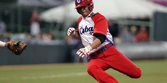FILE - In this Feb. 7, 2015 file photo, Cubas Yadiel Hernández slides safe at the home plate during a Caribbean Series baseball semifinal game against Venezuela in San Juan, Puerto Rico. Cuba is confirming that two baseball players, including Hernández, have defected while in the United States for a series of friendly games against U.S. collegians. (AP Photo/Ricardo Arduengo, File)