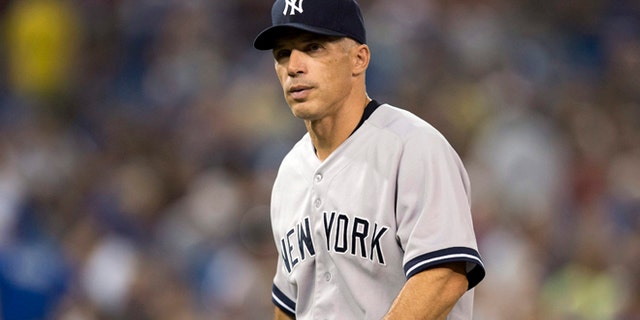 FILE - In this Aug. 28, 2013, file photo, New York Yankees manager Joe Girardi walks off the field during a baseball game against the Toronto Blue Jays in Toronto. Girardi signed a four-year contract extension to stay with the New York Yankees, Wednesday, Oct. 9, 2013. (AP Photo/The Canadian Press, Frank Gunn, File)