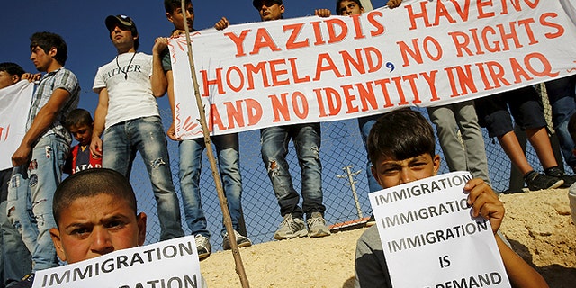 June 20, 2015: Yazidi refugees hold banners at a Syrian and Iraqi refugee camp in the southern Turkish town of Midyat. (REUTERS)