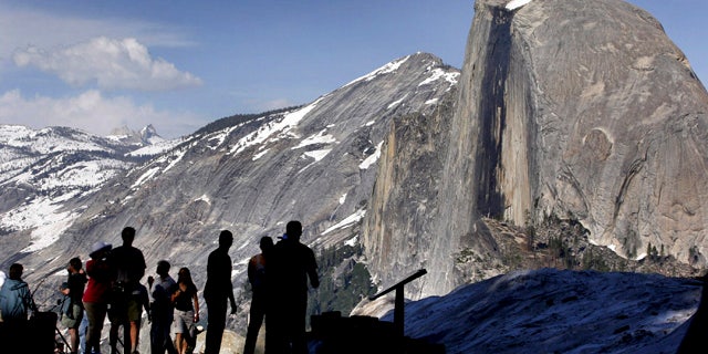 FILE - In this 2005 file photo, visitors view Half Dome from Glacier Point at Yosemite National Park, Calif. (AP Photo/Dino Vournas, File)