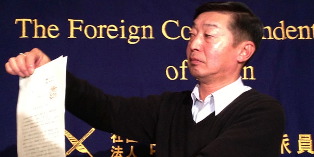 Feb. 12, 2015: Japanese freelance photographer Yuichi Sugimoto shows the press the original document of an order, signed by Foreign Minister Fumio Kishida, which he was given by Japanese foreign ministry officials at his home, during a news conference in Tokyo. Sugimoto said he was forced to give up his passport because he planned a reporting trip to Syria, which the government has stepped up warnings to its citizens not to visit after two Japanese were killed there in a recent hostage crisis.