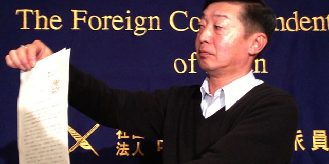 Feb. 12, 2015: Japanese freelance photographer Yuichi Sugimoto shows the press the original document of an order, signed by Foreign Minister Fumio Kishida, which he was given by Japanese foreign ministry officials at his home, during a news conference in Tokyo. Sugimoto said he was forced to give up his passport because he planned a reporting trip to Syria, which the government has stepped up warnings to its citizens not to visit after two Japanese were killed there in a recent hostage crisis.