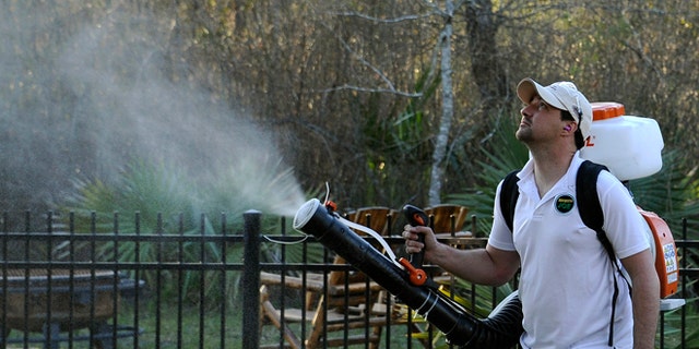 In this Wednesday, Feb. 10, 2016 file photo, Darryl Nevins, owner of a Mosquito Joe franchise, sprays a backyard to control mosquitoes in Houston. Zika has been sweeping through Latin America and the Caribbean in recent months, and the fear is that it will get worse there and arrive in the U.S. with the onset of mosquito season this summer. (AP Photo/Pat Sullivan)