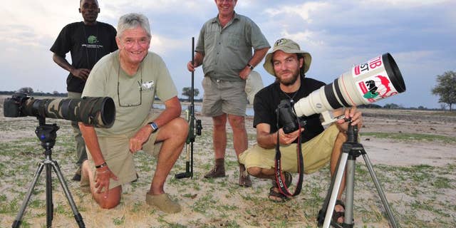 In this photo taken Nov. 9, 2014 photographer Brent Stapelkamp, front right, with colleagues in the Hwange National Park, Zimbabwe. Stapelkamp, a lion researcher and part of a team that had tracked and studied Cecil the lion for nine years darted him and attached a collar last year. He was probably the last person to get up close before Minnesota dentist Walter Palmer killed the now-famous lion with the bushy black mane and, aided by a Zimbabwean professional hunter, cut off its head and skin for trophies. (AP Photo/Derek Whalley)