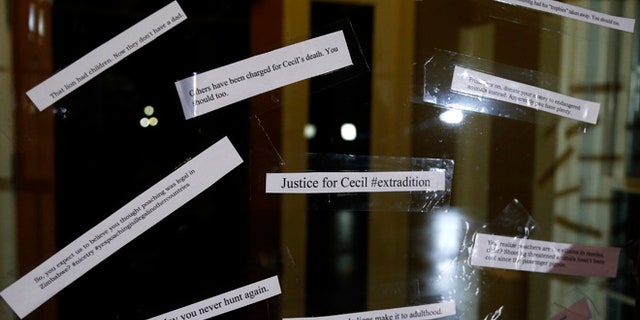 Small notes are placed on the front door of the dental practice of Walter Palmer.