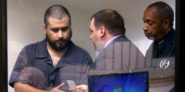 George Zimmerman, left, acquitted in the high-profile killing of unarmed black teenager Trayvon Martin,  leaves court court along with defense counsel Daniel Megaro Tuesday, Nov. 19,  2013, in Sanford, Fla., after Zimmerman's hearing on charges including aggravated assault stemming from a fight with his girlfriend.  (AP Photo/Orlando Sentinel, Joe Burbank, Pool)
