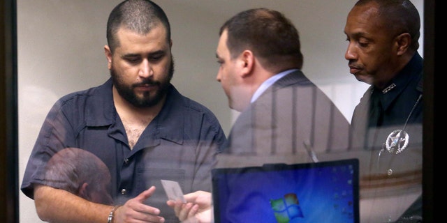George Zimmerman, left, acquitted in the high-profile killing of unarmed black teenager Trayvon Martin, leaves court court along with defense counsel Daniel Megaro Tuesday, Nov. 19, 2013, in Sanford, Fla., after Zimmerman's hearing on charges including aggravated assault stemming from a fight with his girlfriend. (AP Photo/Orlando Sentinel, Joe Burbank, Pool)