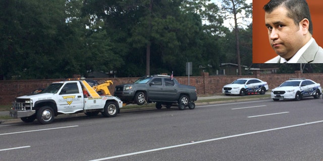 A truck is towed at the scene of a shooting involving George Zimmerman, Monday, May 11, 2015, near Trailhead Park in Lake Mary, Fla. The man who called 911 to report he was involved in the shooting appears to be Matthew Apperson, the same person allegedly involved in a road rage incident Zimmerman last year. (Jeff Weiner/Orlando Sentinel via AP)