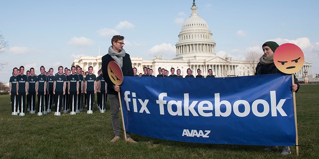 Avaaz campaigners hold a banner in front of 100 cardboard cutouts of the Facebook founder and CEO stand outside the U.S. Capitol, before Mark Zuckerberg testifies before the Senate, in Washington on Tuesday, April 10, 2018.