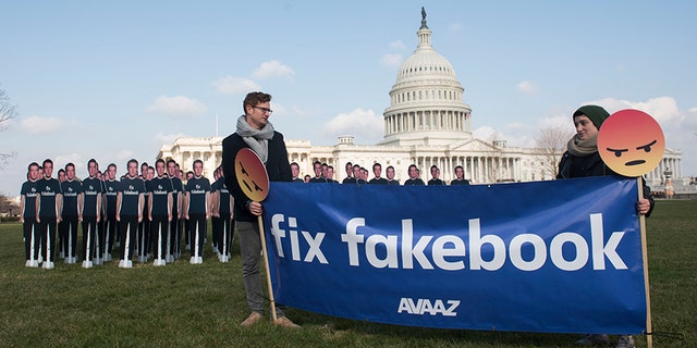 Avaaz campaigners hold a banner in front of 100 cardboard cutouts of the Facebook founder and CEO stand outside the U.S. Capitol, before Mark Zuckerberg testifies before the Senate, in Washington on Tuesday, April 10, 2018.