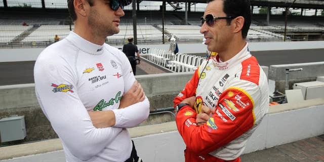 Helio Castroneves, of Brazil, right, talks with Townsend Bell before the start of practice for the Indianapolis 500 auto race at Indianapolis Motor Speedway in Indianapolis, Monday, May 18, 2015. (AP Photo/Darron Cummings)