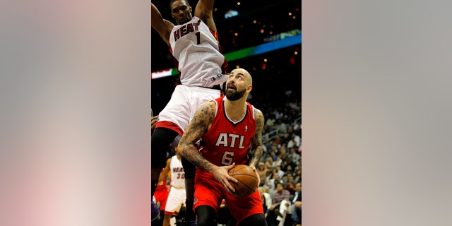 Atlanta Hawks center Pero Antic (6) looks to shoot as he is defended by Miami Heat center Chris Bosh (1) in the fourth period of an NBA basketball game in Atlanta, Monday, Jan. 20, 2014. The Hawks won 121-114. (AP Photo/Todd Kirkland)