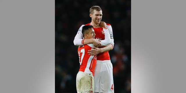 Arsenal's captain Per Mertesacker, right, celebrates with goal scorer Alexis Sanchez at the end the English Premier League soccer match between Arsenal and Southampton at Emirates stadium in London, Wednesday, Dec. 3, 2014. (AP Photo/Kirsty Wigglesworth)