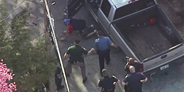 This aerial image made from a helicopter video provided by WHDH shows Richard Simone kneeling and putting his hands on the ground after a high-speed police pursuit in Nashua, N.H., Wednesday, May 11, 2016.