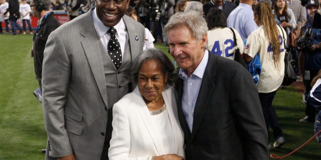 Los Angeles Dodgers owner Magic Johnson, left, Rachel Robinson, widow of baseball player Jackie Robinson, center, and actor Harrison Ford pose for photos during a Jackie Robinson Day ceremony before a baseball game against the San Diego Padres in Los Angeles, Monday, April 15, 2013. (AP Photo/Jae C. Hong)