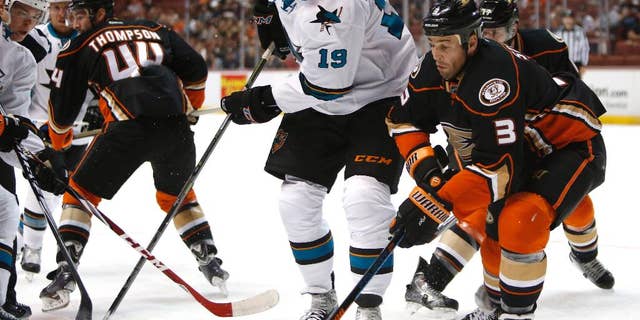 San Jose Sharks center Joe Thornton (19) works for the puck against Anaheim Ducks defenseman Clayton Stoner (3) during the first period of a preseason NHL hockey game in Anaheim, Calif., on Saturday, Oct. 4, 2014. (AP Photo/Christine Cotter)
