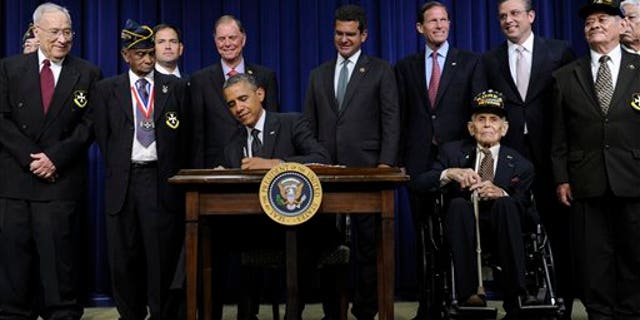 Obama signs H.R. 1726 to award a Congressional Gold Medal to the 65th Infantry Regiment, June 10, 2014.