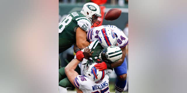 New York Jets quarterback Michael Vick (1) is sacked by Buffalo Bills' Mario Williams (94) and Kyle Williams (95) during the first half of an NFL football game Sunday, Oct. 26, 2014, in East Rutherford, N.J. (AP Photo/Kathy Willens)