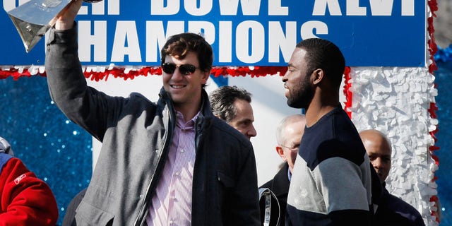 NEW YORK, NY - FEBRUARY 07: New York Giants quarterback Eli Manning # 10 (L) and Super Bowl XLVI MVP holds the Vince Lombardi Trophy as Justin Tuck # 91 (R) of the Giants New York watches during the Giants'  Victory Day Parade on February 7, 2012 in New York City.  The Giants defeated the New England Patriots 21-17 in Super Bowl XLVI.  (Photo by Andrew Burton / Getty Images)