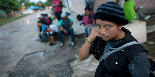 In this June 19, 2014 photo, a 14-year-old Guatemalan girl traveling alone waits for a northbound freight train along with other Central American migrants, in Arriaga, Chiapas state, Mexico. The United States has seen a dramatic increase in the number of Central American migrants crossing into its territory, particularly children traveling without any adult guardian. More than 52,000 unaccompanied children have been apprehended since October. (AP Photo/Rebecca Blackwell)