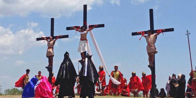 Filipino penitents on wooden crosses take part in a reenactment during Good Friday rituals on Friday, April 14, 2017 at Cutud, Pampanga province, northern Philippines. They were remembering Jesus Christ's suffering and death. (AP Photo/Vicente Gonzales)