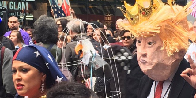 A dancing woman in Islamic garb, left, and a man dressed up as President Trump at the "I Am A Muslim Too" protest.